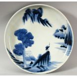 A JAPANESE BLUE AND WHITE PORCELAIN DISH, painted with a figure in a vast landscape, mark to base,
