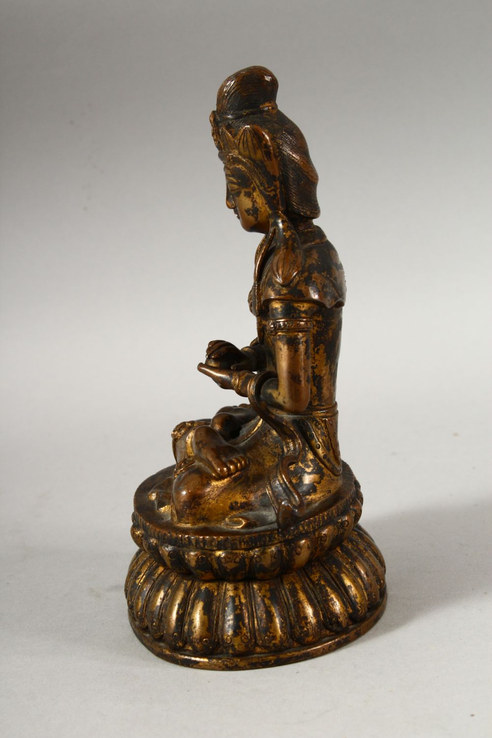 A CHINESE GILT BRONZE FIGURE OF BUDDHA / DEITY - in a seated pose holding a ball, 18cm - Image 2 of 7