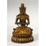 A CHINESE GILT BRONZE FIGURE OF BUDDHA / DEITY - in a seated pose holding a ball, 18cm