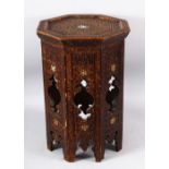 A MOORISH OCTAGONAL OCCASIONAL TABLE with carved decoration, 49cm high, 33cm wide.