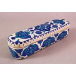 A TURKISH OTTOMAN KUTAHYA POTTERY PEN BOX & COVER, in blue and white floral decoration, 23cm.