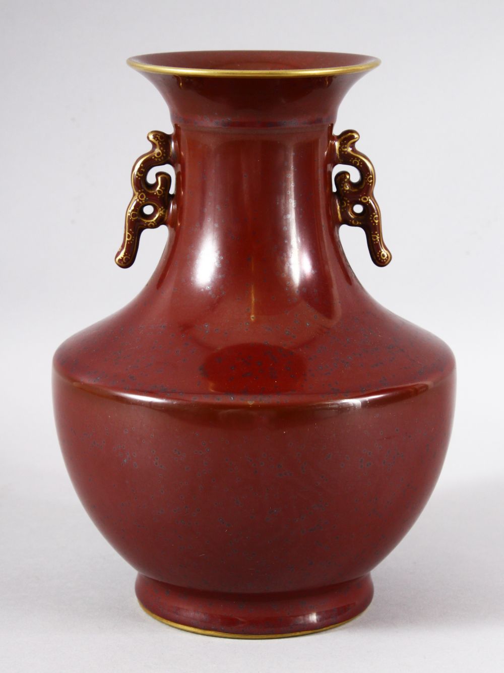 A CHINESE PORCELAIN RED GROUND BALUSTER FORM VASE, with unusual speckled glaze, the rims and handles