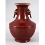 A CHINESE PORCELAIN RED GROUND BALUSTER FORM VASE, with unusual speckled glaze, the rims and handles