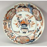 A JAPANESE IMARI / ARITA PORCELAIN DISH, painted with a vase and flowers, the border with lion dogs,