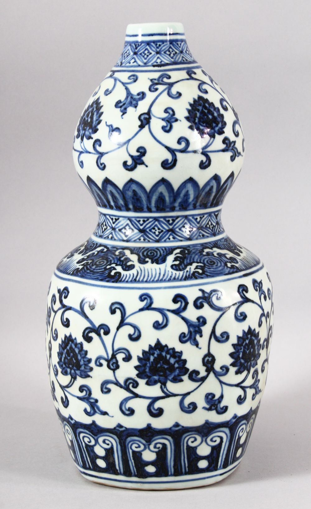 A CHINESE BLUE AND WHITE DOUBLE GOURD VASE, painted with lotus flowers, six character mark to rim,