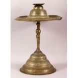 AN ISLAMIC BRASS CANDLESTICK, engraved with bands of calligraphy and decorative motifs, comprised of