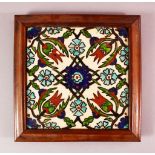 A FRAMED IZNIK STYLE POTTERY TILE SECTION, with a floral motif decoration, 26cm