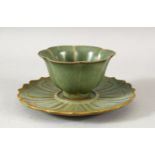 A CHINESE CELADON TEA CUP AND SAUCER, the cup 8.5cm diameter, the saucer 13.5cm diameter.