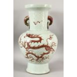 A CHINESE MNIG STYLE CELADON GLAZED CARVED PORCELAIN VASE - decorated with iron red dragons