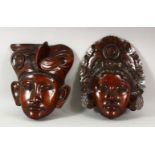 TWO INDONESIAN CARVED HARDWOOD MASKS of a male and female, 27 x 21.5cm and 25cm x 21.5cm.