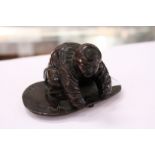 A small Chinese bronze kneeling figure.