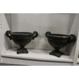 A pair of green patinated pottery urns.