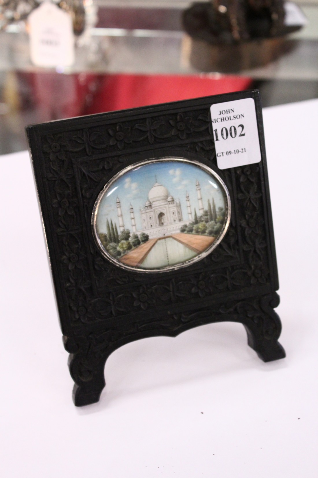 An Indian miniature painting in a carved ebony frame.
