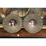 A pair of continental porcelain portrait dishes with impressed brass mounts.
