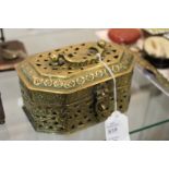 An eastern brass box with pierced decoration and hinged lid.