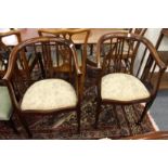 A pair of inlaid mahogany horseshoe shaped armchairs.