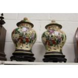 A pair of Chinese crackle glazed ginger jars and covers on hardwood stands.