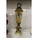 A good decorative continental amber glass goblet and cover decorated with a man holding a large