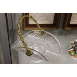 A cut glass basket with brass swing handle.