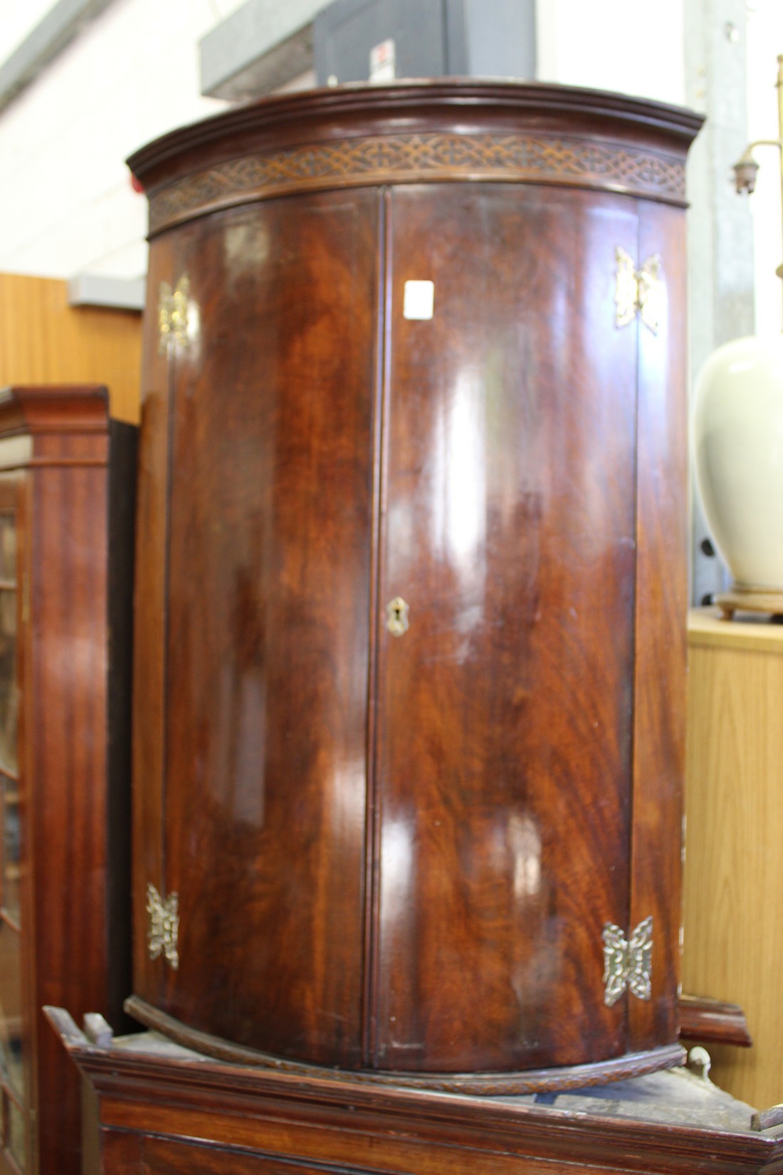 A 19th century mahogany bowfront hanging corner cupboard.