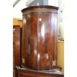 A 19th century mahogany bowfront hanging corner cupboard.