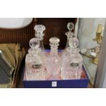 A pair of cut glass whisky decanters and three others.