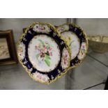 Two late 19th century floral decorated plates, each with blue and gilt borders decorated with floral