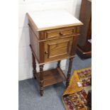 A French oak and marble top bedside cupboard.