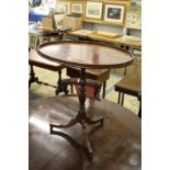 A mahogany oval tripod table.