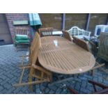 An extending garden table with six chairs and a parasol.