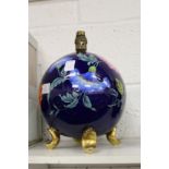 A floral decorated globe shaped lamp base.