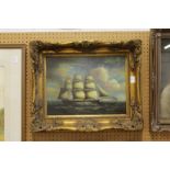 A decorative picture depicting a Man O' War in full sail, in a decorative gilt frame.