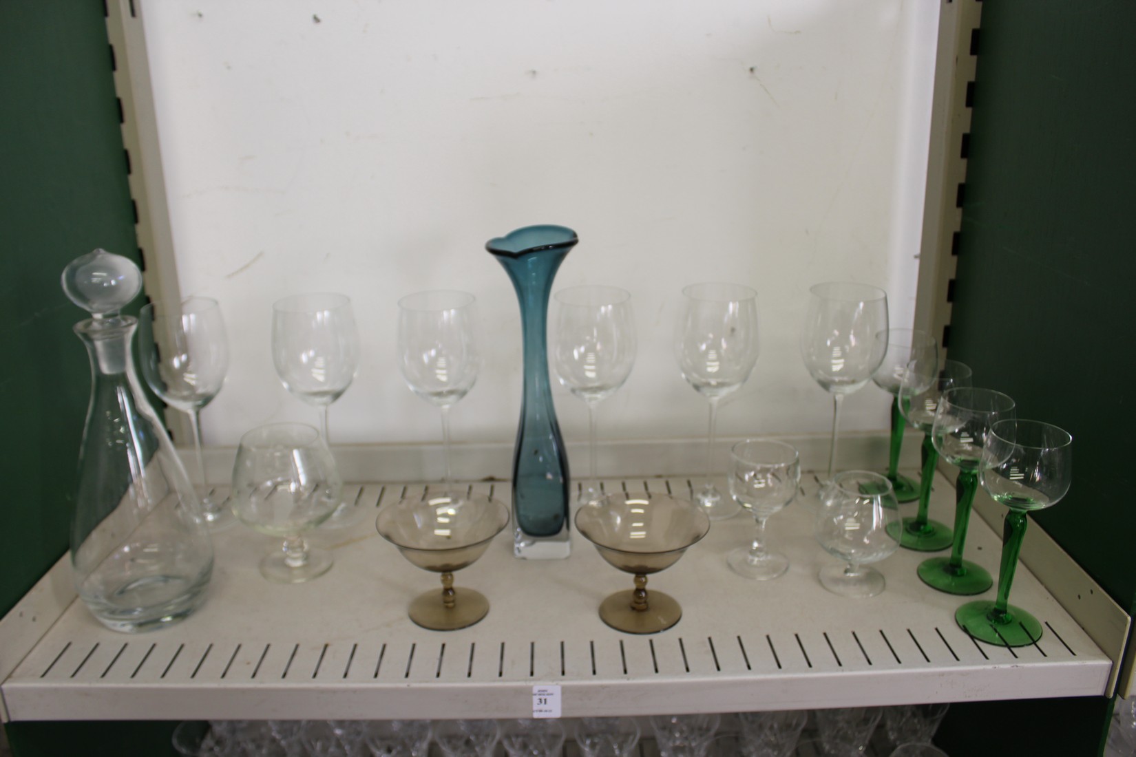 A modern glass decanter, a stylish glass vase and other glassware.