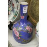 A Chinese blue ground mallet shaped bottle vase painted with flowering trees.