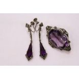 An Art Deco style brooch set with an amethyst coloured stone together with a pair of matching drop