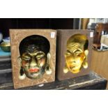 A pair of unusual moulded Chinese plaques with faces.