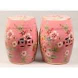 A PAIR OF CHINESE PORCELAIN BARREL SEATS, pink ground decorated with butterfiles and flowers 18ins