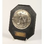 A GERMAN PRESENTATION PLAQUE with a plated cast metal roundel depicting soldiers firing a field gun,
