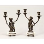 A PAIR OF FRENCH STYLE BRONZE CHERUBS AND MARBLE TWIN BRANCH CANDELABRAS. 12ins high.
