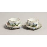 A MINIATURE PAIR OF 19TH CENTURY MEISSEN ENCRUSTED CUPS AND SAUCERS. Cross swords mark in blue