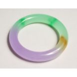 A MULTI COLOURED JADE BANGLE.