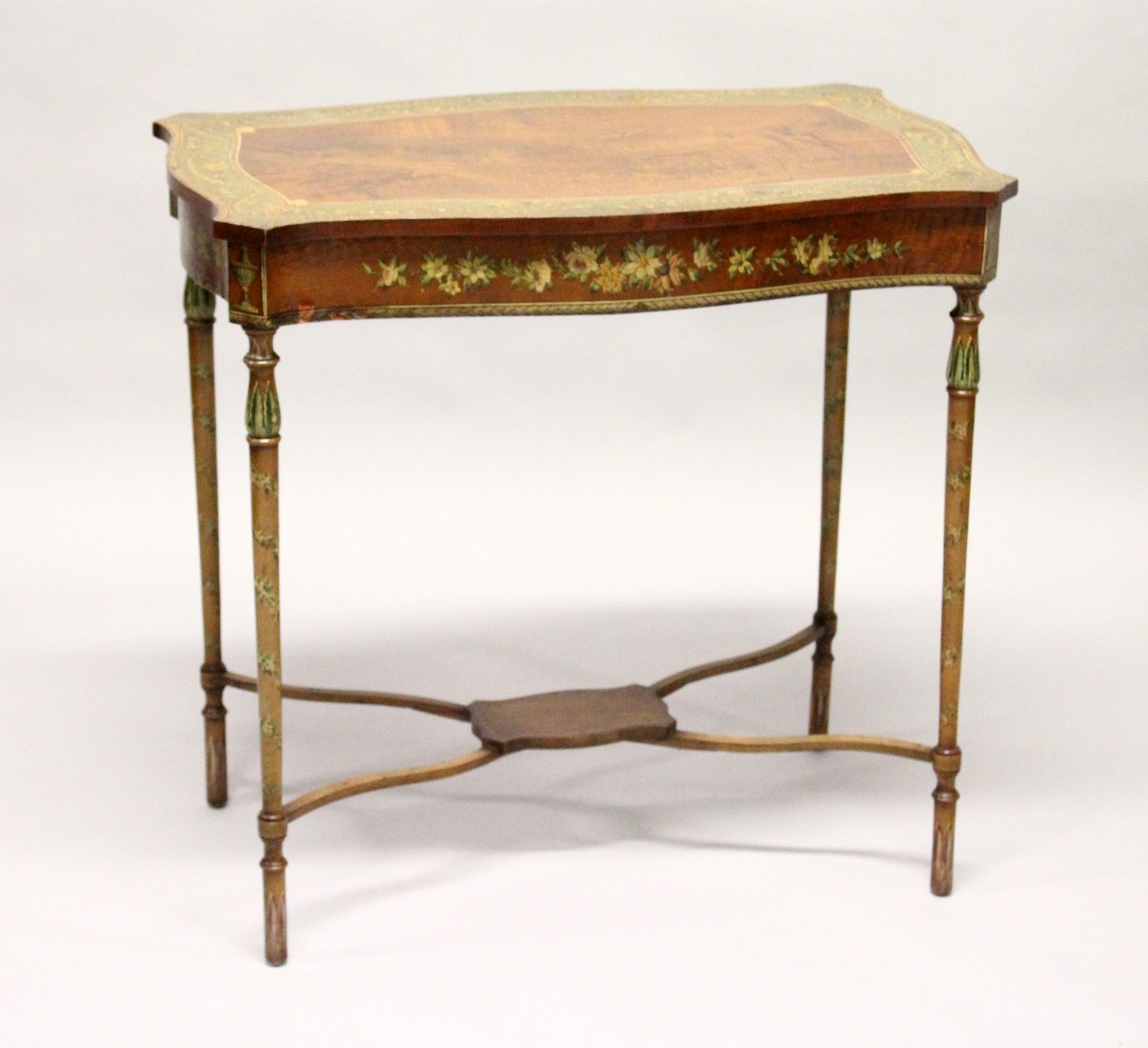 A GOOD EDWARDIAN SATINWOOD AND PAINTED OCCASIONAL TABLE of serpentine outline, the border, frieze