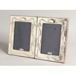 A PAIR OF SILVER ART NOUVEAU STYLE PHOTOGRAPH FRAMES. 8ins x 5.5ins.