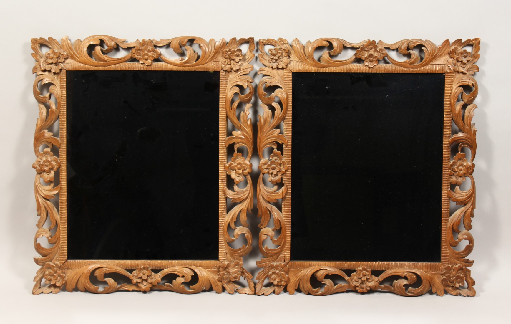 A PAIR OF 19TH CENTURY MIRRORS with leaf and flower carved wood frames 22ins x 19ins