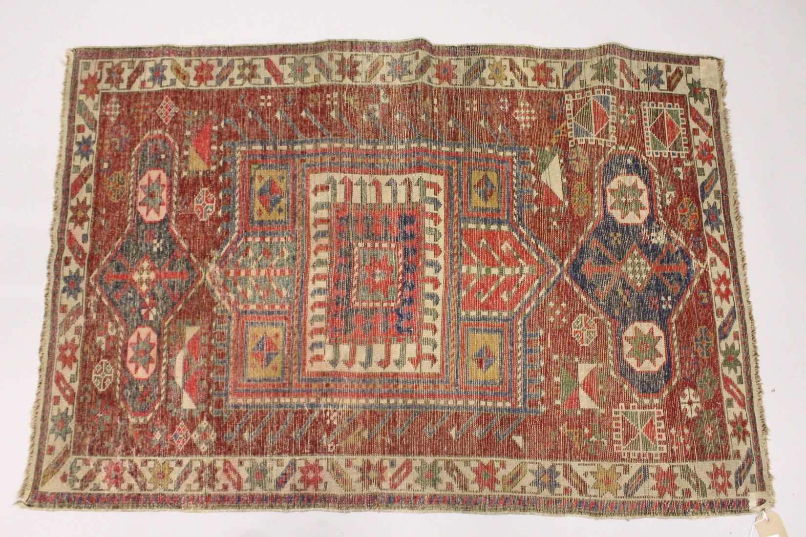 AN UNUSUAL SMALL CAUSASIAN SHIRWAN RUG, claret ground with stylised design. 4ft 2ins x 2ft 10ins - Image 2 of 2