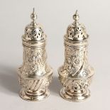A PAIR OF ROCOCCO STYLE SILVER BALLISTER SHAPE PEPPERETTE, with embossed and chased floral