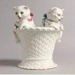 A CONTINENTAL GROUP, TWO CATS in a white basket 7ins high.