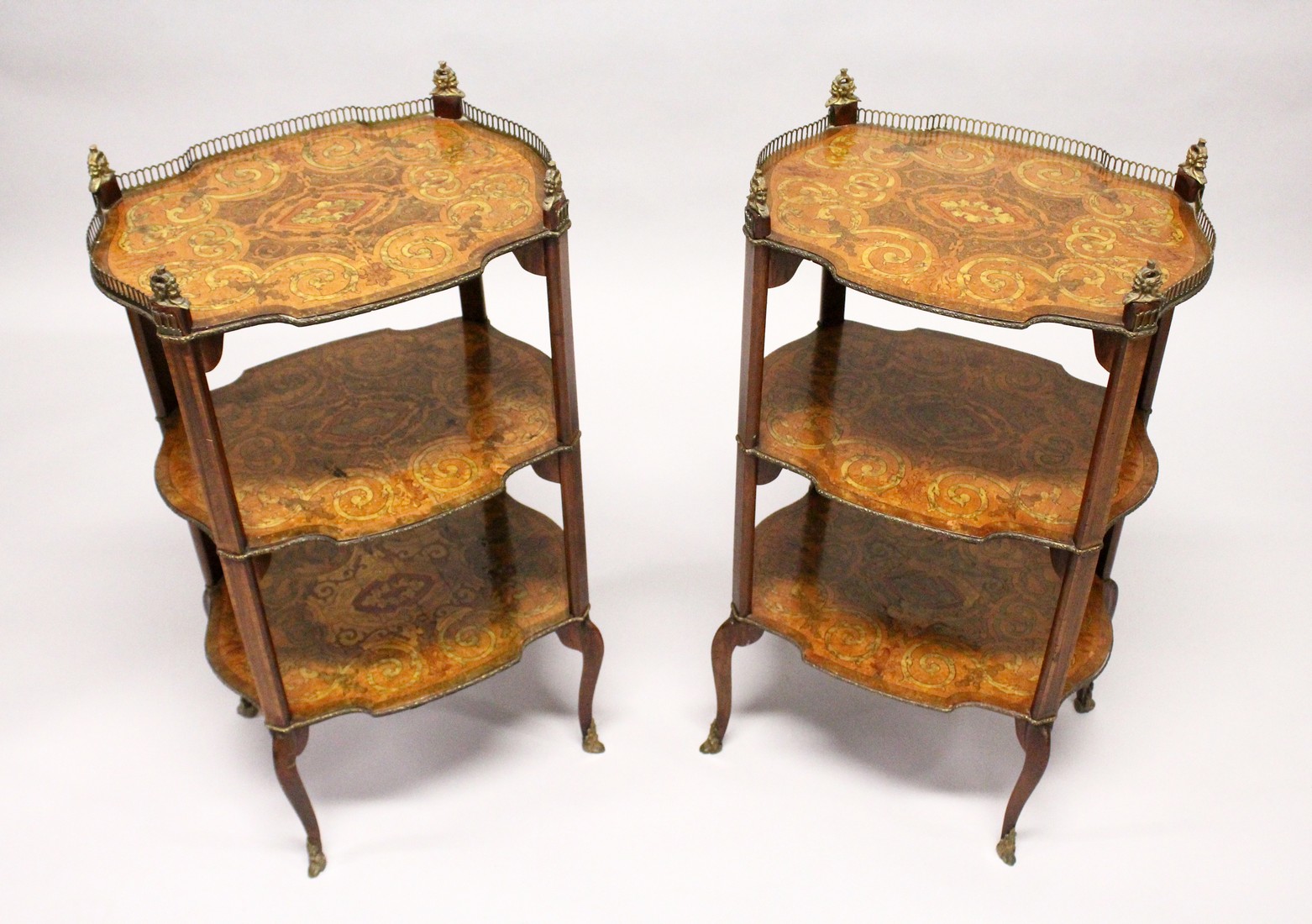 A PAIR OF EARLY 20TH CENTURY FRENCH MARQUETRY AND ORMOLU MOUNTED THREE TIER ETAGERES, with galleried