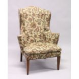 A GEORGIAN STYLE MAHOGANY WING ARM CHAIR with loose cushions on tapering legs.