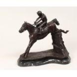 A CAST BRONZE GROUP DEPICTING A HORSE AND JOCKEY JUMPING A FENCE, on a marble base. 1ft 1ins high